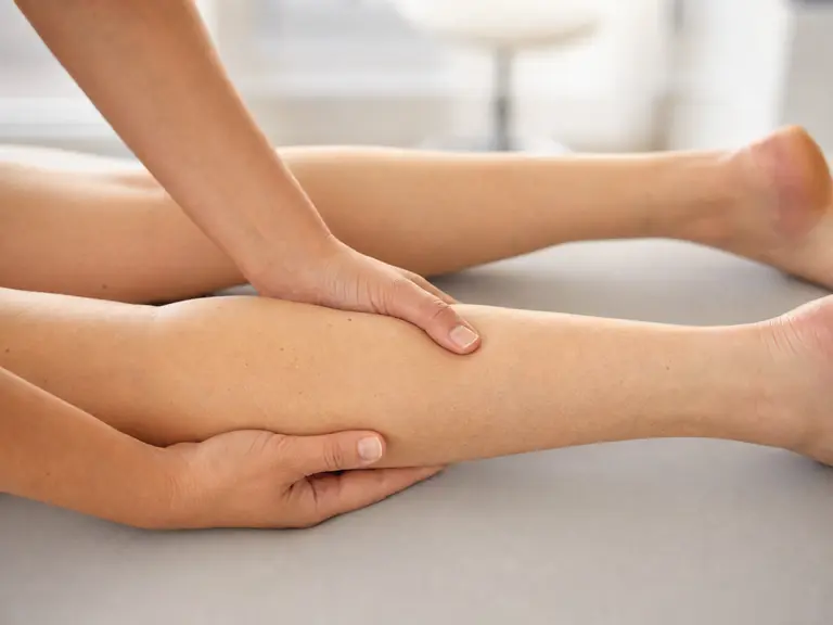 Manuelle Lymphdrainage am Bein einer Patientin.